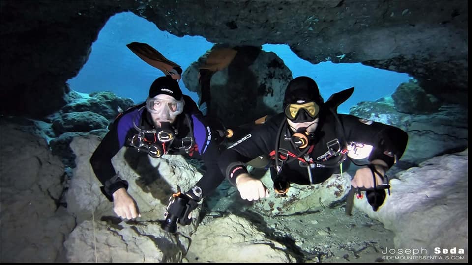 Two divers smiling for the camera inside a cave opening at Ginnie Springs